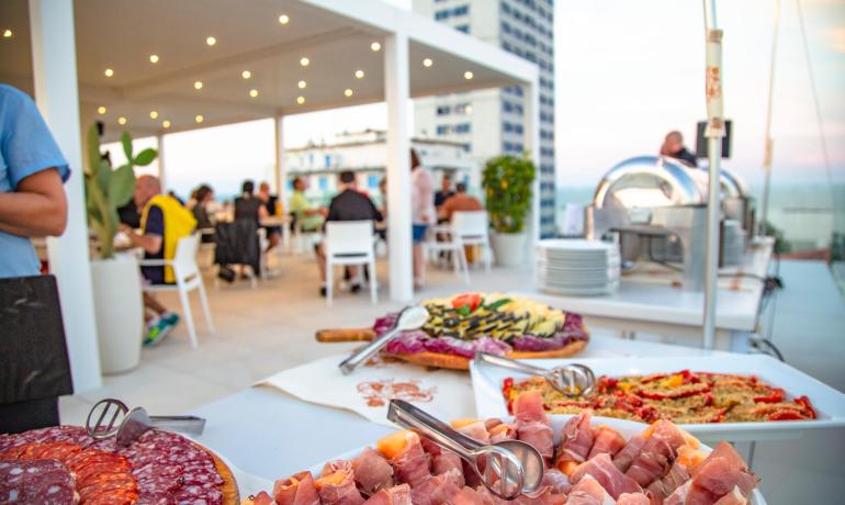 Buffet en terrasse avec charcuterie et plats de légumes.