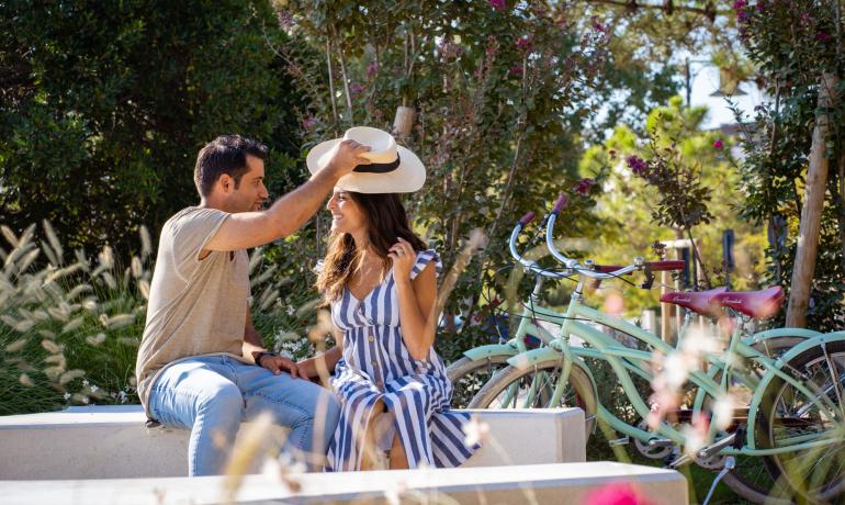 Couple heureux avec vélos, il lui met un chapeau.